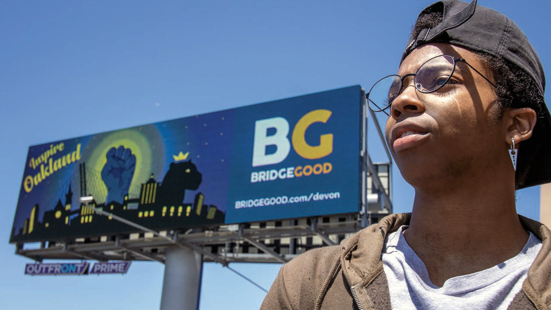 Inspire Oakland billboard featuring student artist Devon, BRIDGEGOOD.com/devon, against a blue sky