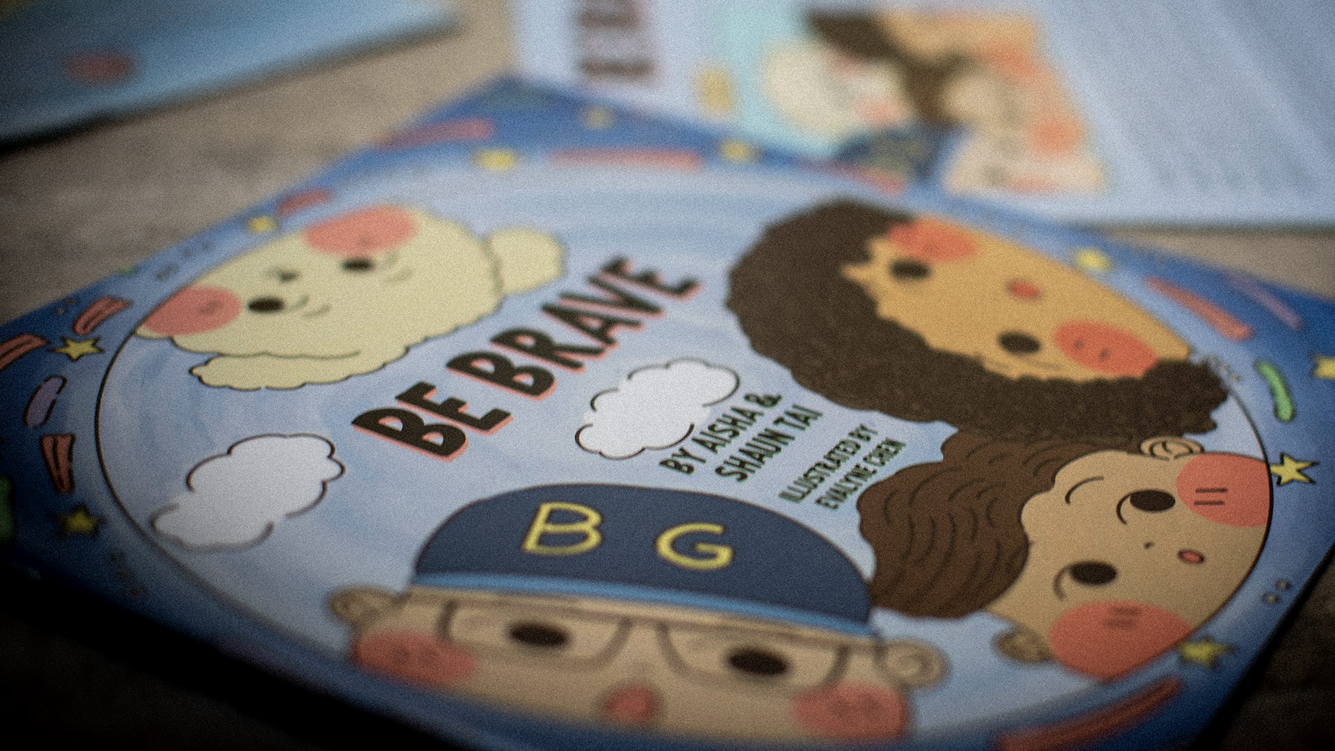 Be Brave picture book cover by Aisha and Shaun Tai, illustrated by Evalyne Chen, with a character in a BG cap
