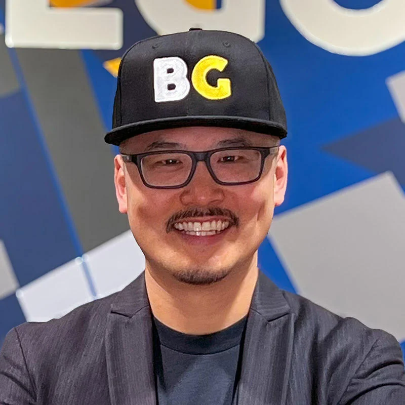 Shaun Tai, Executive Director at BRIDGEGOOD smiling inside their Oakland, California studio.